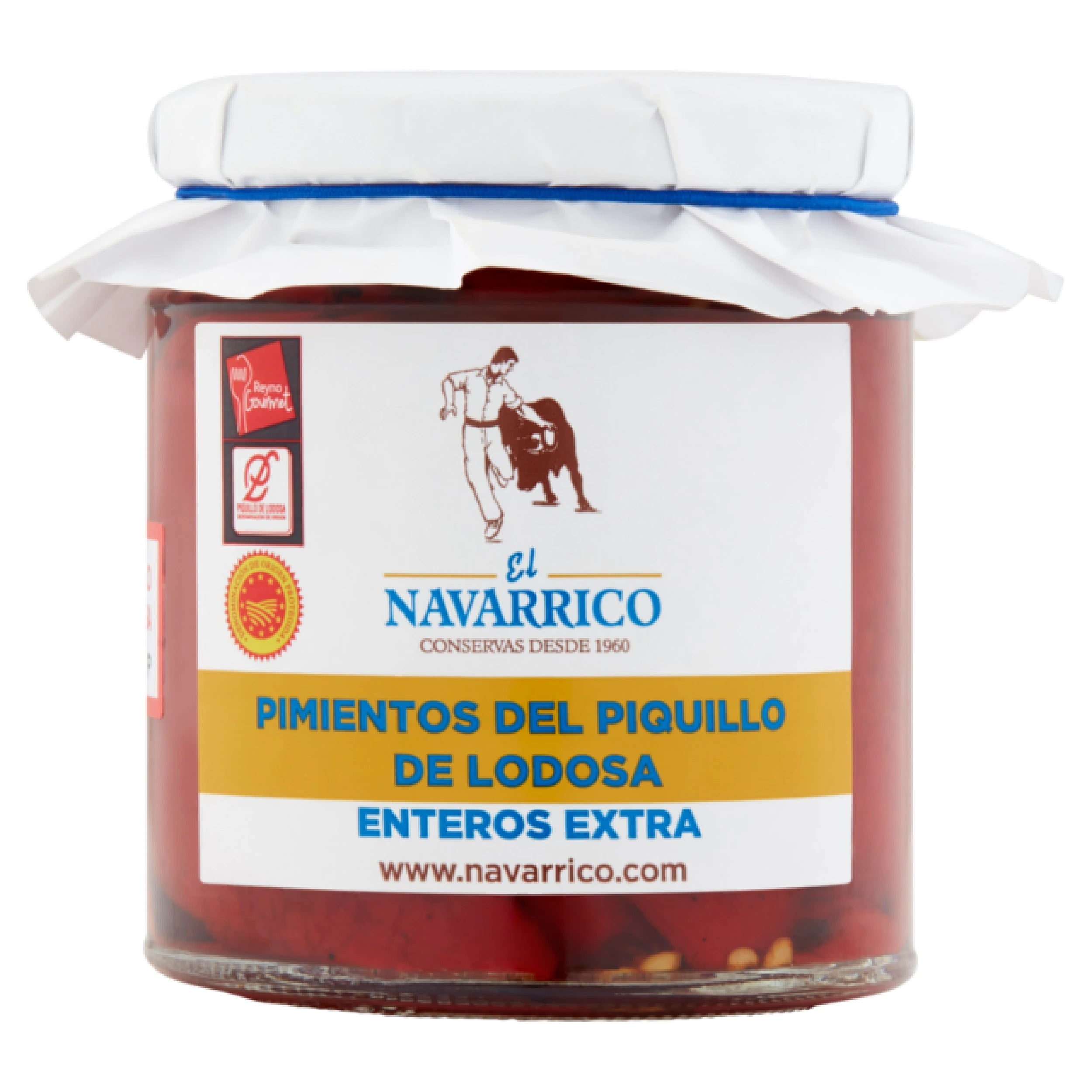 Glass jar containing whole red peppers from Piquillo de Lodosa, with a white label displaying the El Navarrico brand. The lid is white with a blue rim, and the label features a matador logo, quality certifications, and product information in Spanish. The contents of the jar are visible, showing bright red peppers bathing in their juice.