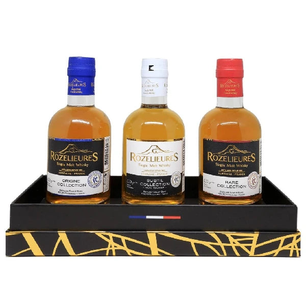 Rozelieures tasting set containing three 20cl single malt whisky bottles: Subtil (white), Origine (blue), and Rare (red), presented on a decorated black tray.