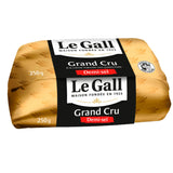 Image of Grand Cru salted churned butter. A golden and creamy block of butter, artisanally shaped, rests on a surface. Its texture appears rich and unctuous, reflecting its production from raw cream. The butter exudes a premium appearance, showcasing the traditional expertise of Master Buttermakers and its unique 24-hour manufacturing process. One can almost imagine its subtle nutty notes and authentic taste.