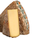 Golden wheel of Comté Grande Réserve, an iconic hard cheese from Franche-Comté. Its granular rind reveals a dense paste speckled with tyrosine crystals. Complex aromas of roasted hazelnuts and brown butter intertwine with subtle fruity and herbaceous notes, testament to a meticulous aging process of 30 to 42 months. This exceptional cheese, with 32-34% fat content, promises a rich and refined tasting experience, ideal when paired with Jura wines.