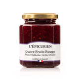 Jar of Artisanal Four Red Berry Jam with visible fruit chunks. Rich ruby-red spread on rustic bread, surrounded by fresh strawberries, raspberries, cherries, and redcurrants.