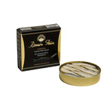 Ramón Peña 'Black Label' sardines in olive oil on toasted bread with sautéed onions and peppers, served alongside a glass of Chardonnay. Tin of premium sardines visible.