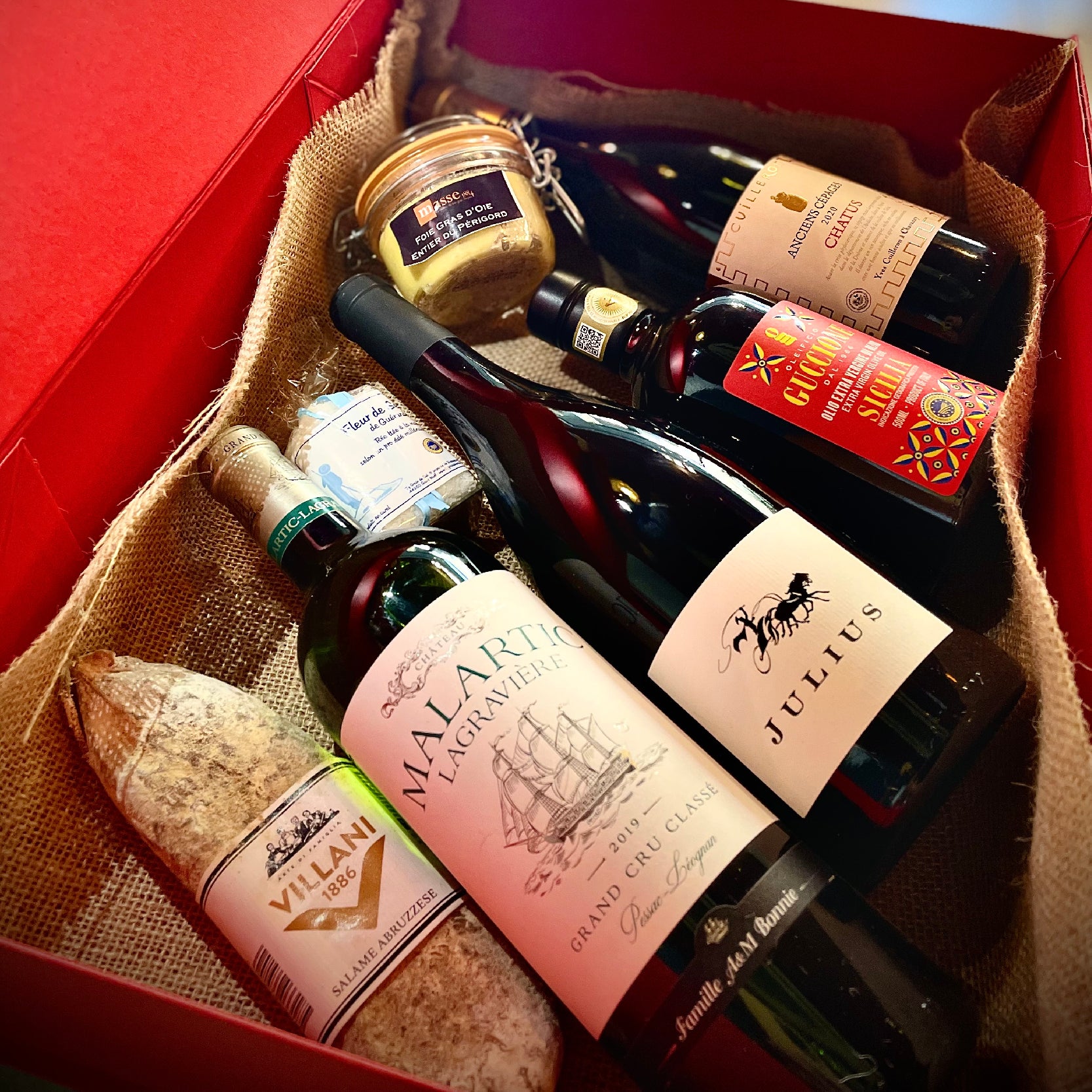 Roman gift hamper featuring fine wines, gourmet olive oil, premium salami, and whole goose foie gras from Baron Max Wines.