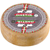 Onetik Tomme Mixte – A rustic Basque cheese wheel made from goat and sheep milk, showcasing a natural rind and firm, marbled interior