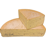 Close-up of artisanal smoked pepper raclette cheese made from raw cow’s milk — creamy texture, rich aroma, and perfect for melting.