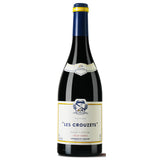 A bottle of Les Crouzets 2021 from Domaine Cassagne et Vitailles, showcasing a deep garnet color. This wine from the Languedoc region is primarily made from Grenache and aged to bring out rich and complex aromas. It features a bouquet with notes of ripe red berries, plums, and spices. The palate is well-balanced and structured, offering flavors of rich fruit, hints of licorice, and a subtle oak finish. 